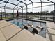 Screened pool with built-in sun loungers, an umbrella stand, and a picturesque lake view at 2659 Magpie Way, Sanford, FL 32773