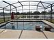 Screened pool with built-in sun loungers, an umbrella stand, and a picturesque lake view at 2659 Magpie Way, Sanford, FL 32773