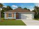 Charming single-story home with a two car garage, well-maintained lawn, and beautiful blue exterior at 2940 Moulin Rd, Davenport, FL 33837