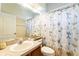 Cozy bathroom with a single sink vanity, toilet, and shower featuring a floral patterned shower curtain at 305 Grand Reserve Dr, Davenport, FL 33837