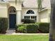 Inviting front entrance with manicured hedges, arched details, and a covered porch at 305 Grand Reserve Dr, Davenport, FL 33837