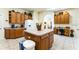Bright kitchen with tile floors, center island, wooden cabinets, and a dedicated desk area at 305 Grand Reserve Dr, Davenport, FL 33837