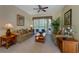 Comfortable living room with plush seating, side tables, and large windows overlooking the backyard at 305 Grand Reserve Dr, Davenport, FL 33837