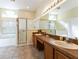 Spacious main bathroom featuring double sinks, a soaking tub, and a separate glass-enclosed shower at 305 Grand Reserve Dr, Davenport, FL 33837