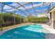Screened pool and spa area surrounded by lush greenery under a bright blue sky at 305 Grand Reserve Dr, Davenport, FL 33837