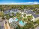 Aerial view of community pool and hot tub surrounded by lush landscaping and colorful buildings at 411 Old Farm Ln, Winter Springs, FL 32708