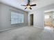 Empty carpeted bedroom features a ceiling fan, closet and ensuite entries, with a window at 411 Old Farm Ln, Winter Springs, FL 32708