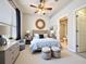 A comfy bedroom featuring a serene bed, stylish decor, and an open bathroom view at 411 Old Farm Ln, Winter Springs, FL 32708