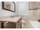 Bathroom features a vanity with marble countertop, decorative tile walls, and a tub at 416 Davis Dr, Orlando, FL 32803