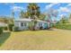 Charming single-story home featuring a vibrant turquoise front door, white window shutters, and mature palm trees at 416 Davis Dr, Orlando, FL 32803