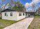 Charming single-story home with a white brick exterior and black trim, a covered carport, and a concrete driveway at 425 Walnut St, Daytona Beach, FL 32114