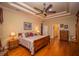 Relaxing main bedroom featuring hardwood floors, tray ceiling, and traditional furnishings at 4846 Lake Juliana Reserve Dr, Auburndale, FL 33823