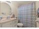 Cozy bathroom featuring a round mirror, chevron shower curtain, and single sink vanity at 5019 Log Wagon Rd, Ocoee, FL 34761