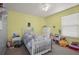 Bright bedroom with yellow and blue walls, carpet floors, and a ceiling fan at 5019 Log Wagon Rd, Ocoee, FL 34761