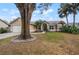 Traditional single-story home with tan siding, a manicured lawn, and arched entryway at 5019 Log Wagon Rd, Ocoee, FL 34761