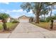 Charming home featuring a wide driveway, lush landscaping, and mature trees at 5019 Log Wagon Rd, Ocoee, FL 34761