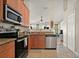Open kitchen layout, featuring stainless steel appliances and view to living room at 5019 Log Wagon Rd, Ocoee, FL 34761