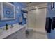 Bathroom featuring blue painted walls, a glass-enclosed shower, and decorative accents for a serene experience at 5201 S Atlantic Ave # 301A, New Smyrna Beach, FL 32169