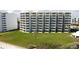 Exterior view of the multi-story condominium building with a spacious lawn and convenient beach access at 5201 S Atlantic Ave # 301A, New Smyrna Beach, FL 32169