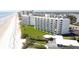 White condo building on the beach with green grass and a yellow star showing the location at 5201 S Atlantic Ave # 301A, New Smyrna Beach, FL 32169
