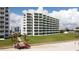 Exterior shot of the white condo building and green grass at 5201 S Atlantic Ave # 301A, New Smyrna Beach, FL 32169