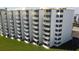 Exterior side view of the white condo building featuring private balconies on each unit at 5201 S Atlantic Ave # 301A, New Smyrna Beach, FL 32169