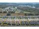 Aerial view of a new neighborhood with rows of modern homes and green lawns by a railway and distant lake at 5342 Maddie Dr, Haines City, FL 33844