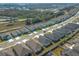 A grid of new homes feature manicured lawns and sidewalks along a treeline in an orderly suburban neighborhood at 5342 Maddie Dr, Haines City, FL 33844