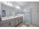 Bathroom with double vanity and a glass enclosed shower with gray tiling and hardware at 5342 Maddie Dr, Haines City, FL 33844