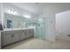Bathroom with double vanity and a glass enclosed shower with gray tiling and hardware at 5342 Maddie Dr, Haines City, FL 33844