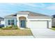 Charming single-story home featuring a two-car garage, blue shutters, and a well-manicured lawn at 5342 Maddie Dr, Haines City, FL 33844