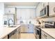 Bright kitchen showcasing a central island, stainless steel appliances, and modern light grey cabinetry at 5342 Maddie Dr, Haines City, FL 33844