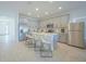 Spacious eat-in kitchen with an island, stainless steel appliances, light grey cabinets, and bar stools at 5342 Maddie Dr, Haines City, FL 33844