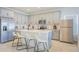 Well-lit kitchen boasts a large island, modern appliances, light grey cabinets, and trendy bar stools at 5342 Maddie Dr, Haines City, FL 33844