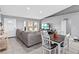 Spacious living room with a combined seating and dining area featuring tile flooring and grey colored walls at 542 Bent Oak Loop, Davenport, FL 33837