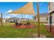 Lush backyard features outdoor living space shaded by a sail cover with comfortable patio furniture at 574 Lady Grace Pl, Deland, FL 32724