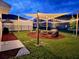 Backyard at dusk featuring shade sail, patio, and ambient lighting at 574 Lady Grace Pl, Deland, FL 32724
