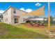 Large backyard featuring sail shade cover, patio seating, and a well-maintained lawn at 574 Lady Grace Pl, Deland, FL 32724