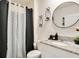 Modern bathroom with patterned shower curtain, vanity with granite countertop, and a round mirror at 574 Lady Grace Pl, Deland, FL 32724