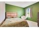 Compact bedroom featuring a comfortable bed, soft lighting, and green accent wall at 574 Lady Grace Pl, Deland, FL 32724