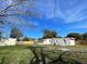 A well-kept backyard showcasing a building, fence, and green grass under a clear blue sky at 580 Ryan Ave, Apopka, FL 32712