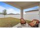 Covered patio with two cushioned chairs and a beautiful fenced backyard at 5861 Bar Ranch Rd, St Cloud, FL 34771