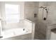 A luxurious bathroom features a soaking tub and a walk-in shower with unique tile at 608 Bluebill Ct, Kissimmee, FL 34759