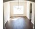 View of chandelier and dining room with dark wood-look floors and bright natural light at 608 Bluebill Ct, Kissimmee, FL 34759