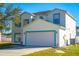 Two-story home featuring blue trim, a driveway, a 2-car garage, and grass lawn at 608 Bluebill Ct, Kissimmee, FL 34759