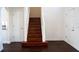 View of wooden stairs with white railing leading to upper level, adjacent to two doors at 608 Bluebill Ct, Kissimmee, FL 34759