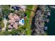 Stunning aerial view of the luxury home with pool, lush landscaping and private lake access with boat dock at 6126 Kirkstone Ln, Windermere, FL 34786