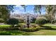Elegant two-story home featuring a front fountain, manicured landscaping and a stone and stucco facade at 6126 Kirkstone Ln, Windermere, FL 34786