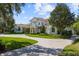 Stately home with a circular driveway, lush lawn, and meticulously maintained landscaping under a bright sky at 6126 Kirkstone Ln, Windermere, FL 34786