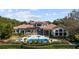 Expansive backyard featuring a luxurious pool, manicured landscaping, and covered outdoor living spaces at 6126 Kirkstone Ln, Windermere, FL 34786